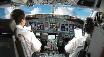 A pilot and co-pilot inside a cockpit.