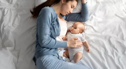 A mother sleeps with her baby