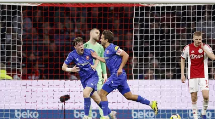 Sondre Ørjasæter and Bart van Rooij of FC Twente celebrate the 1–2 while Ajax goalkeeper Maarten Paes looks on during the Dutch Eredivisie match between AFC Ajax and FC Twente at the Johan Cruijff ArenA on April 4, 2026, in Amsterdam, Netherlands.
