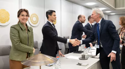 PRO Senator Paul Rosenmöller shakes Prime Minister Rob Jetten's hand after receving majority support for his motion to scrap the Cabinet's plans to increase state pension age more rapidly. Deputy Prime Minister Dilan Yeşilgöz is next to Jetten, smiling at the camera. 7 April 2026
