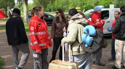 Red Cross volunteers speaking with people arriving at the asylum registration center in Ter Apel, May 2026