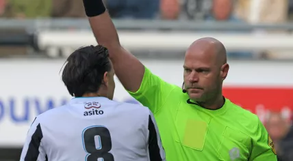 Dutch referee Rob Dieperink handing a yellow card to Heracles midfielder Mario Engels, October 19, 2025.