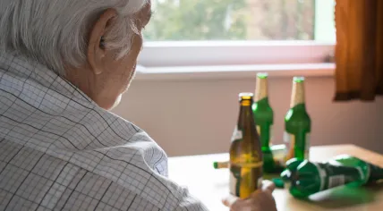 Elderly man drinks beers.