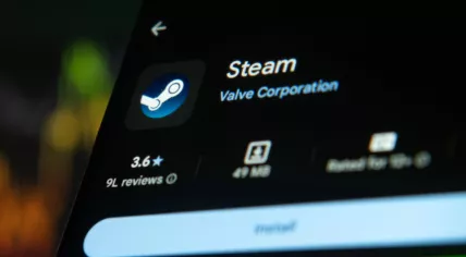 Steam app icon on Google Play Store on a tablet with a laptop keyboard as a background