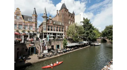 Kayakers paddle past the terraces along the Oudegracht in Utrecht. 30 July 2025