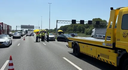 Several people use an umbrella to create shade on a scorching hot day after a collision on the A4, June 24, 2026.