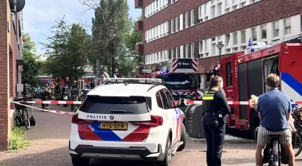 Police talk to residents as firefighters respond to an explosion and fire on Ombilinstraat in Amsterdam. 20 June 2026