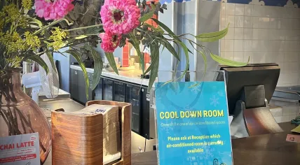 A sign in an Amsterdam-Oost café promotes a free, public cooling space inside the Stayokay hostel. 24 June 2026