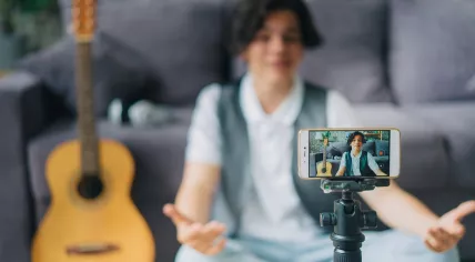 Kidfluencer - teenage boy using smartphone to record video for internet vlog