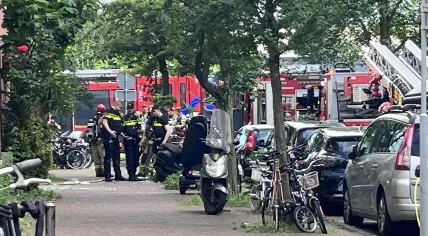 Police talk to residents as firefighters respond to an explosion and fire on Ombilinstraat in Amsterdam. 20 June 2026