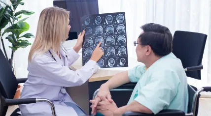 A neurologist talks about the brain scans with her patient.