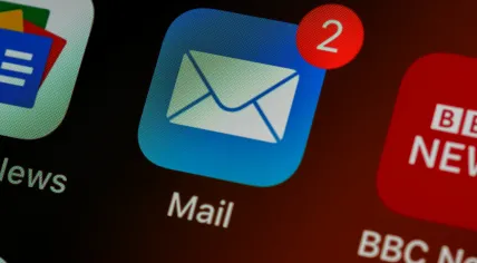 The Apple Mail app icon on an iPhone screen alongside icons for Google News and BBC News. 2020
