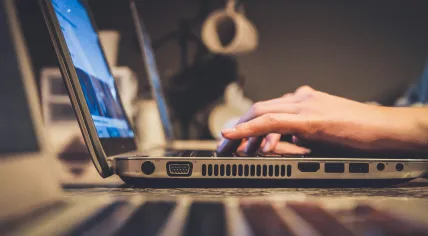 A silver laptop with several USB, audio, and video ports. 2018