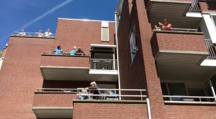 Residents of De Gooyer in Amsterdam Oost applaud singer Marcel Fokker after a surprise concert. April 24, 2020