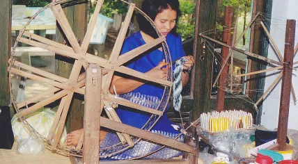 1280px-Female_and_spinning_mill_for_silk_Thailand