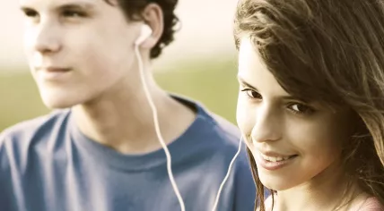 1280px-Teens_sharing_a_song