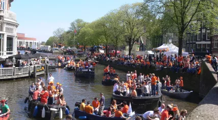 1280px-Amsterdam_-_Koninginnedag_2012_-_canal_near_Muntplein