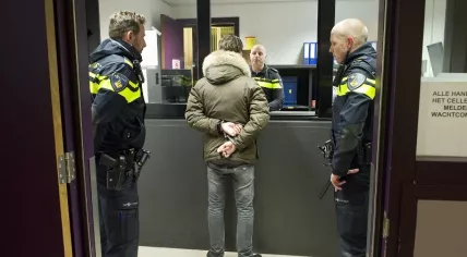 arrestant-staat-voor-politiebalie