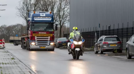 motoragent-rijdt-voor-vrachtwagen-uit