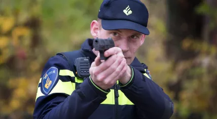 A police officer aiming his service weapon