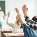 Pupils raising their hands in class