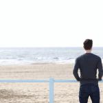 A man standing alone looking out on the Dutch coast