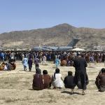 Hundreds of people gather near a U.S. Air Force C-17 transport plane at a perimeter at the international airport in Kabul, Afghanistan, Monday, 16 August 2021