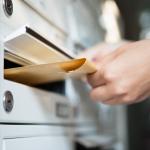 Woman taking letter out of mailbox