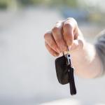 Person in grey shirt handing over car keys