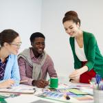 Stock image of desingers gathering around table
