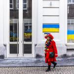 Carnival celebrators walk past pro-Ukraine graffiti on the Russian consulate in Maastricht, 1 March 2022