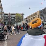 A man wearing a Dutch flag walking through the Bredeweg Festival in Amsterdam on King’s Day. 27 April 2023