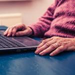 Elderly woman working on a laptop