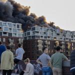 Bystanders watch a raging fire in an apartment building on Joan Muyskenweg in Amsterdam-Oost.