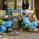 Piles of rubbish bags dumped alongside a waste bin on a street in the center of Amsterdam, August 2022