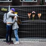 Two people embrace in front of a home on Heiman Dullaertplein in Rotterdam, where a woman, 39, and her daughter, 14, were shot dead a day earlier. 29 September 2023