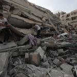 Palestinians inspect the ruins of Aklouk Tower destroyed in Israeli airstrikes in Gaza City on October 8, 2023.