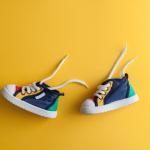 Colorful baby shoes on a yellow background