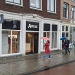 People walking past the Amac retail store on Prins Hendrikkade in Amsterdam. 22 April 2023