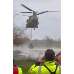 A Dutch military Chinook helicopter lowers a net filled with rubble to help cut off a dam breach in Maastricht. 6 January 2024