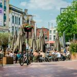  People sitting at outdoors restaurant in the main square of Eindhoven on sunny spring day