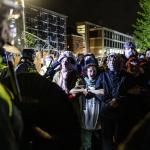 Pro-Palestinian demonstrators cling to each other as the riot police remove them from the University of Amsterdam campus, 7 May 2024