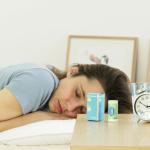 Woman sleeping with benzodiazepine sleeping pills on her bedside table