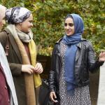 Three Muslim women in hijabs chatting outside