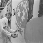 Jan Cremer paints a fence on the Nieuwendijk in Amsterdam