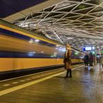 People waiting on the platform of Tilburg station while a NS intercity enters the station