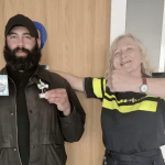 Hadjer Al-Ali, a homeless man in Amsterdam, receives a sliver thumb award from the police for turning in a wallet containing 2,000 euros, 23 June 2024