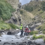 Spanish rescue workers helping a hiker in the Pyrenees mountains in the Huesca province