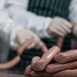 Butchers processing sausages