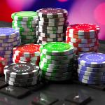 Casino chips and dice stacked up on a laptop